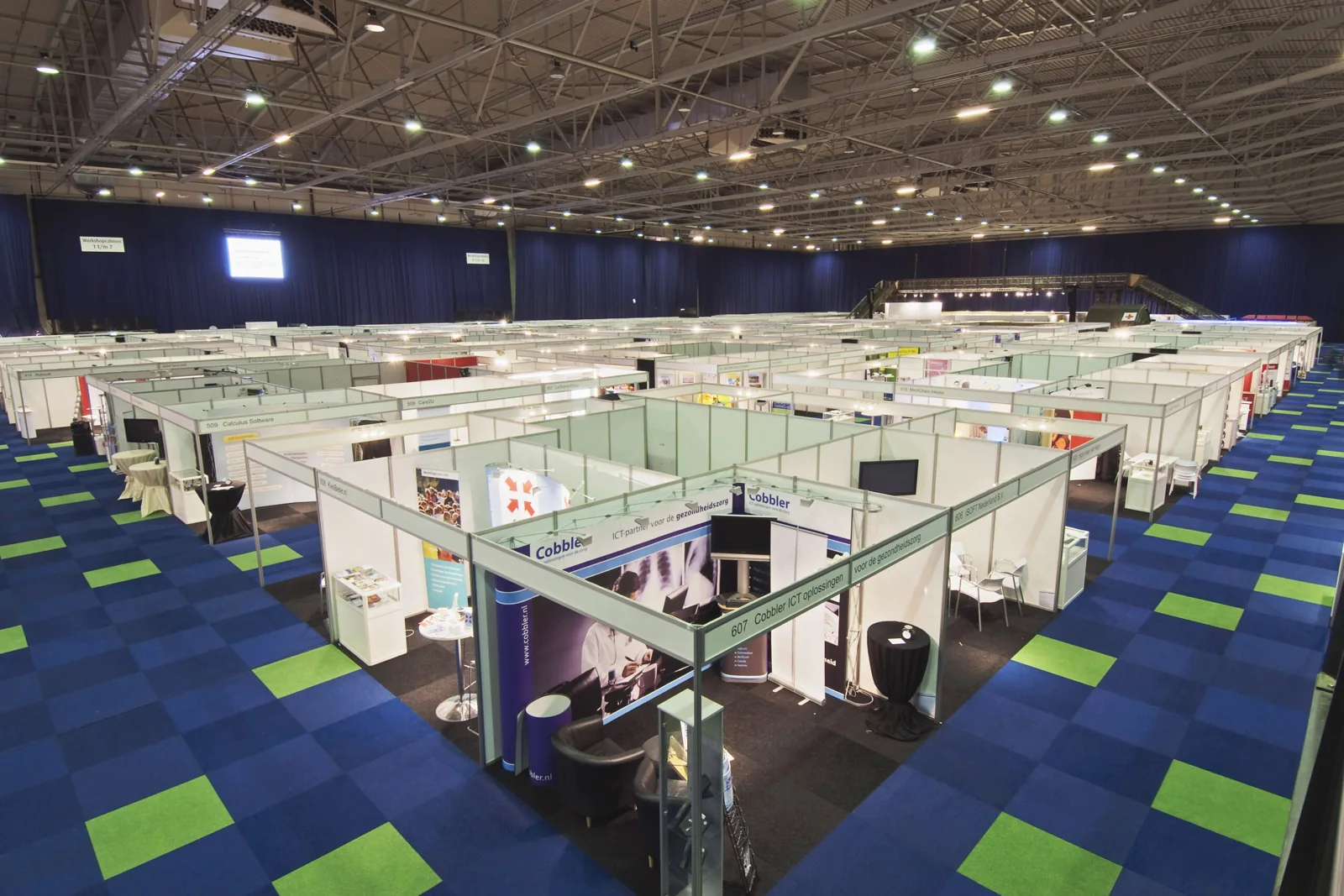 Een complete beurshal ingericht met stands en tapijt door HRSB